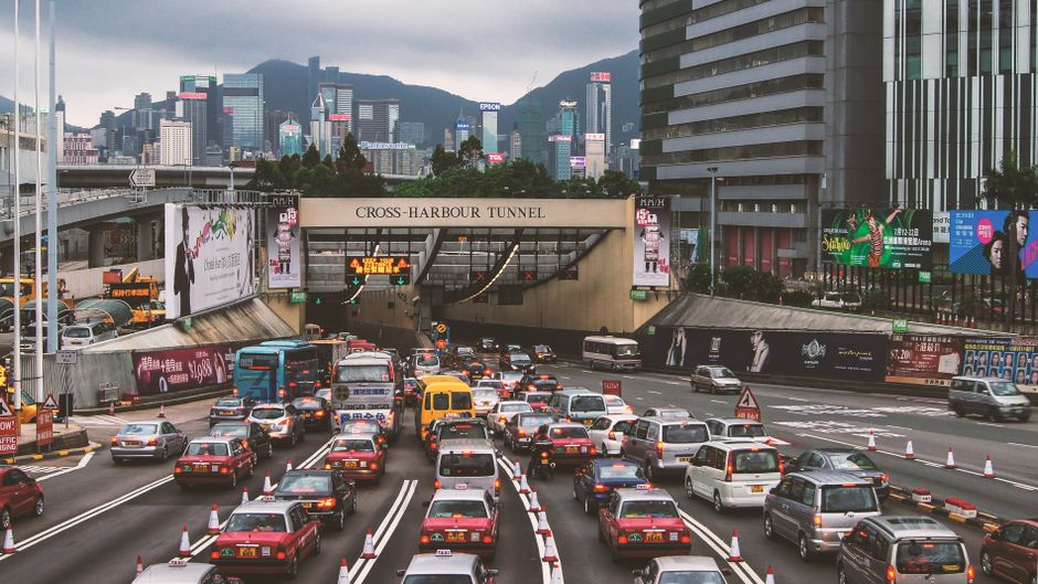 Heavy traffic congestion at Hong Kong's Cross-Harbour Tunnel with cityscape.